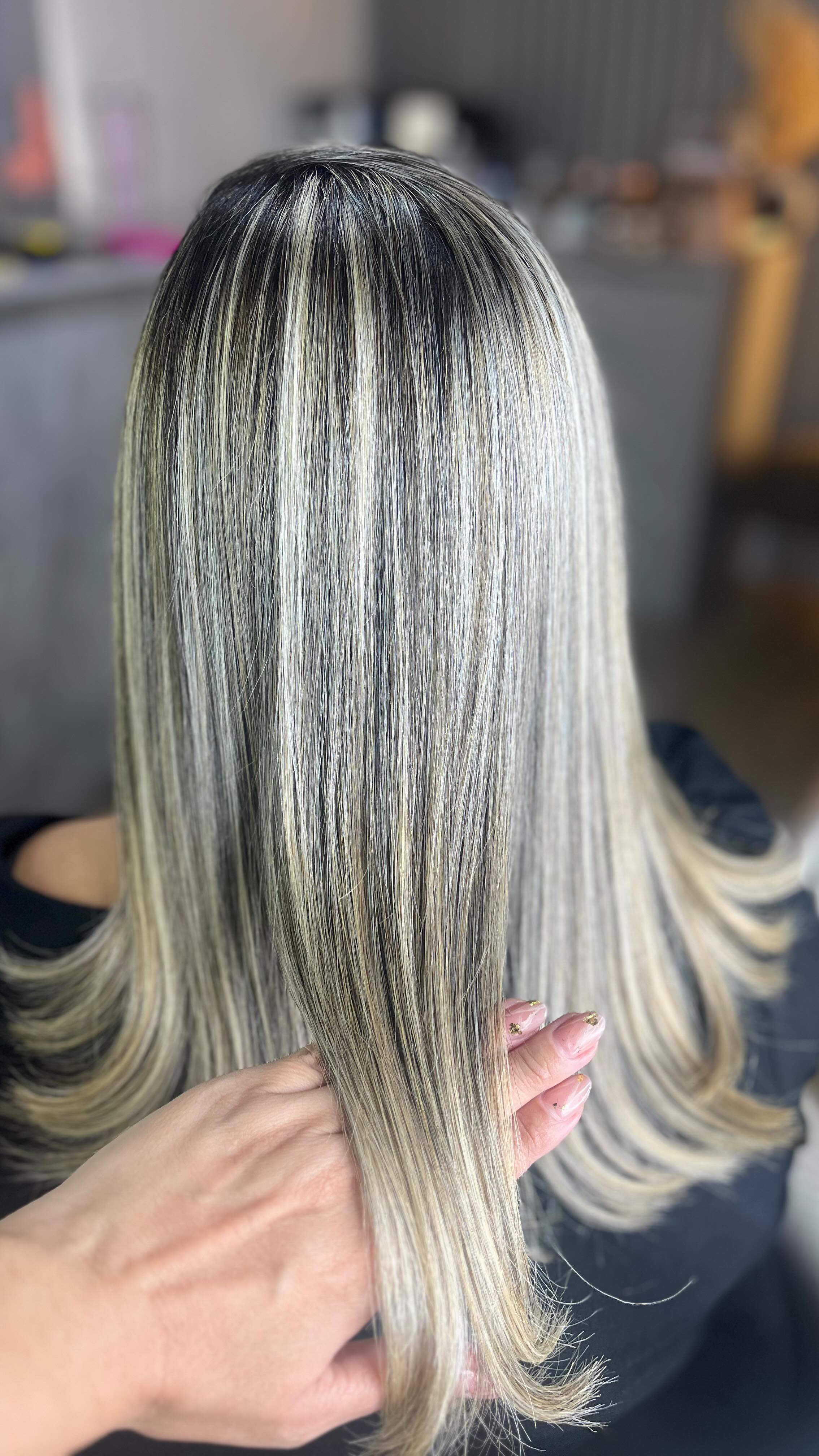 Loiro liso com mechas finas seguradas pela mão